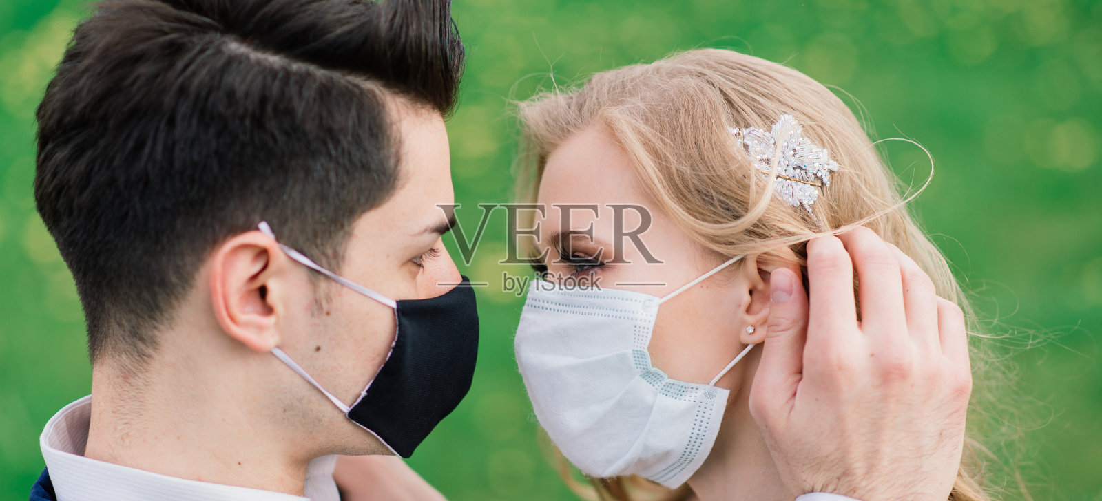 新婚夫妇戴着医用口罩在公园里散步。冠状病毒、疾病、防护、生病、生病流感欧洲庆祝活动取消。照片摄影图片