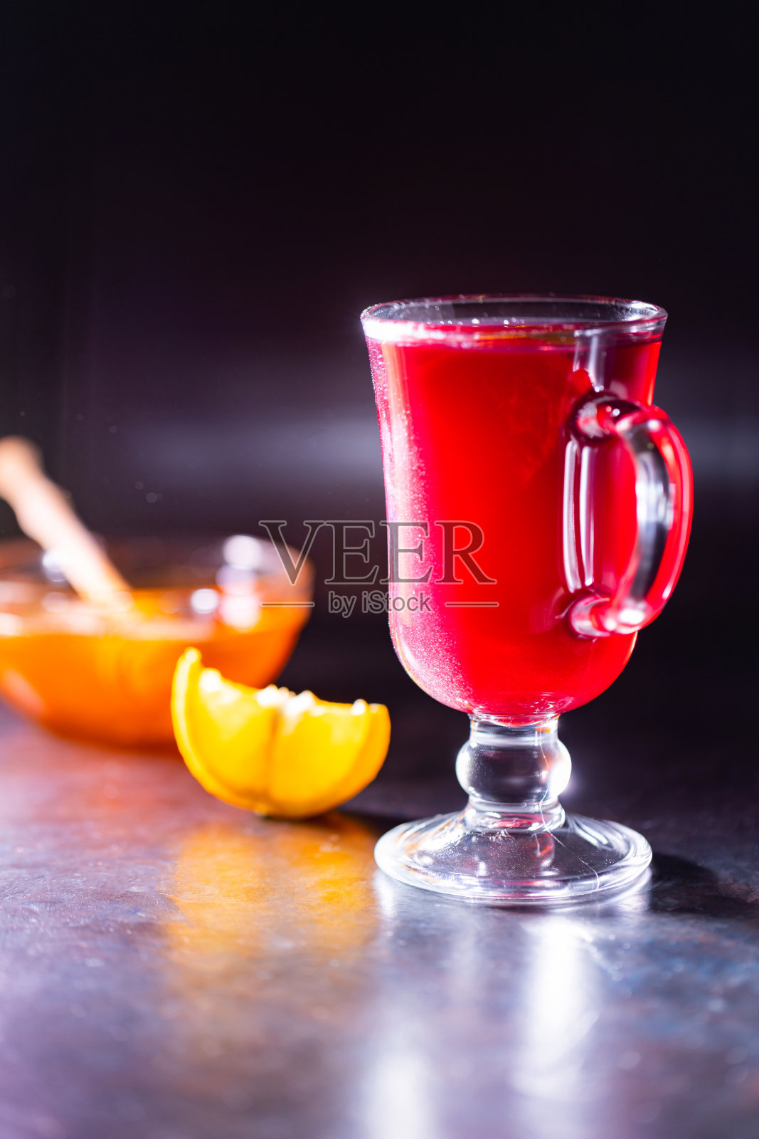 黑色背景下的圣诞热葡萄酒。一杯热葡萄酒在背光下闪闪发光。圣诞节期间的传统热饮照片摄影图片