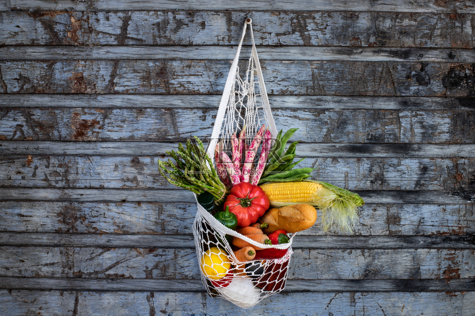 新鲜的水果和蔬菜在网袋里。照片摄影图片