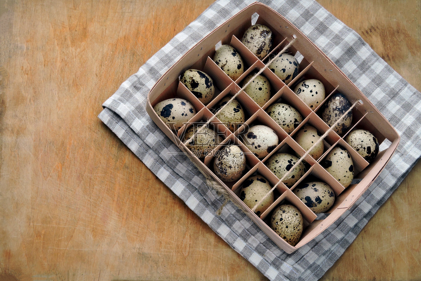 鹌鹑蛋放在木托盘里。照片摄影图片