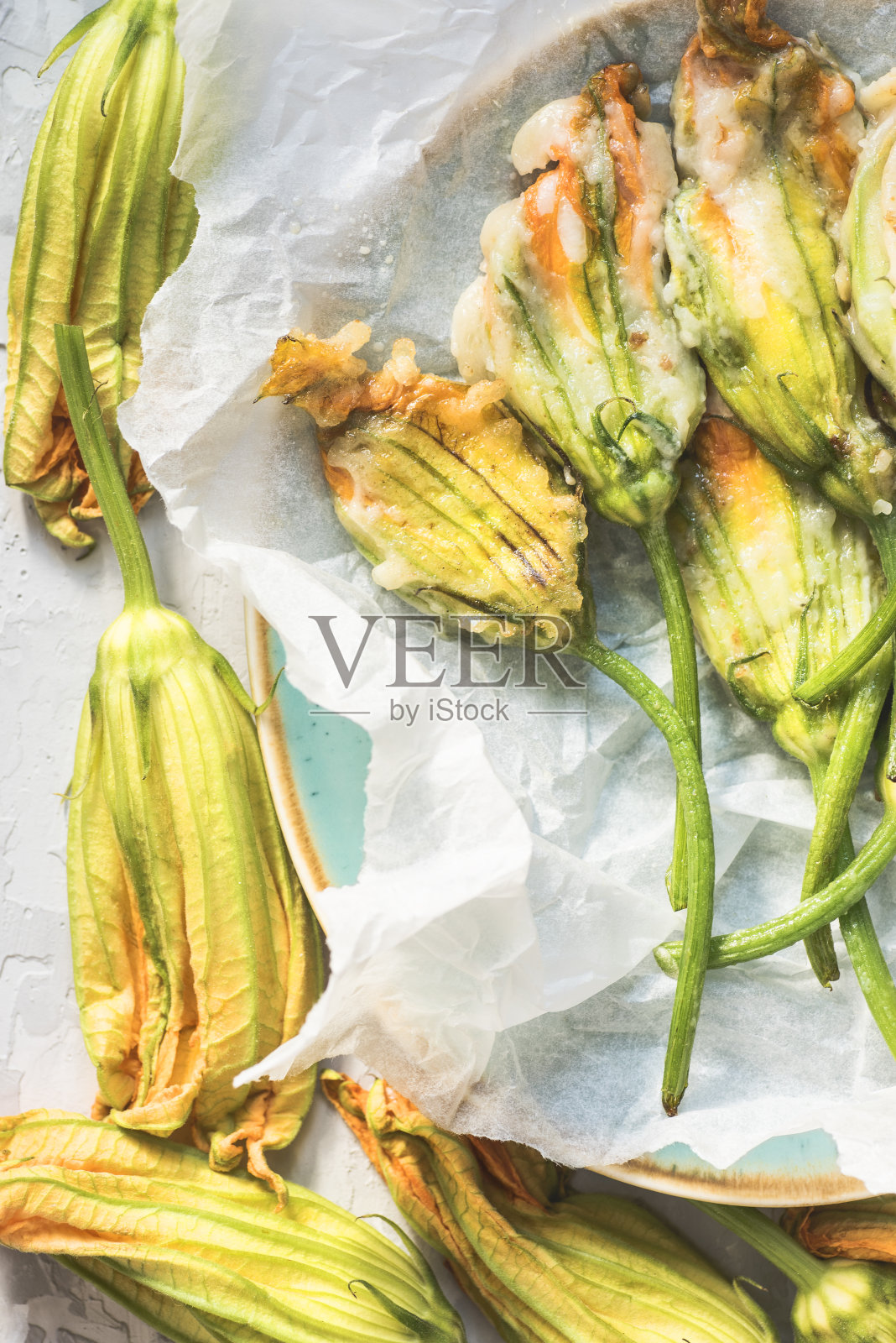 传统的意大利炸西葫芦花(小胡瓜,南瓜花)或扎卡花与莫札雷拉和盐渍凤尾鱼在灰色的混凝土背景照片摄影图片