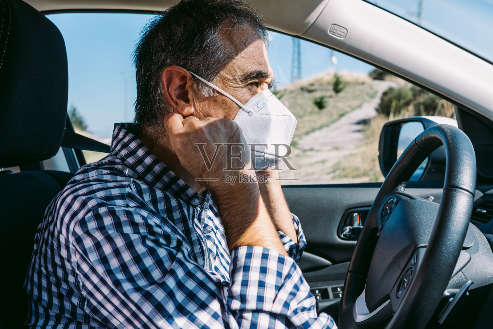 成年男子在车内戴口罩以保护自己免受covid-19感染照片摄影图片