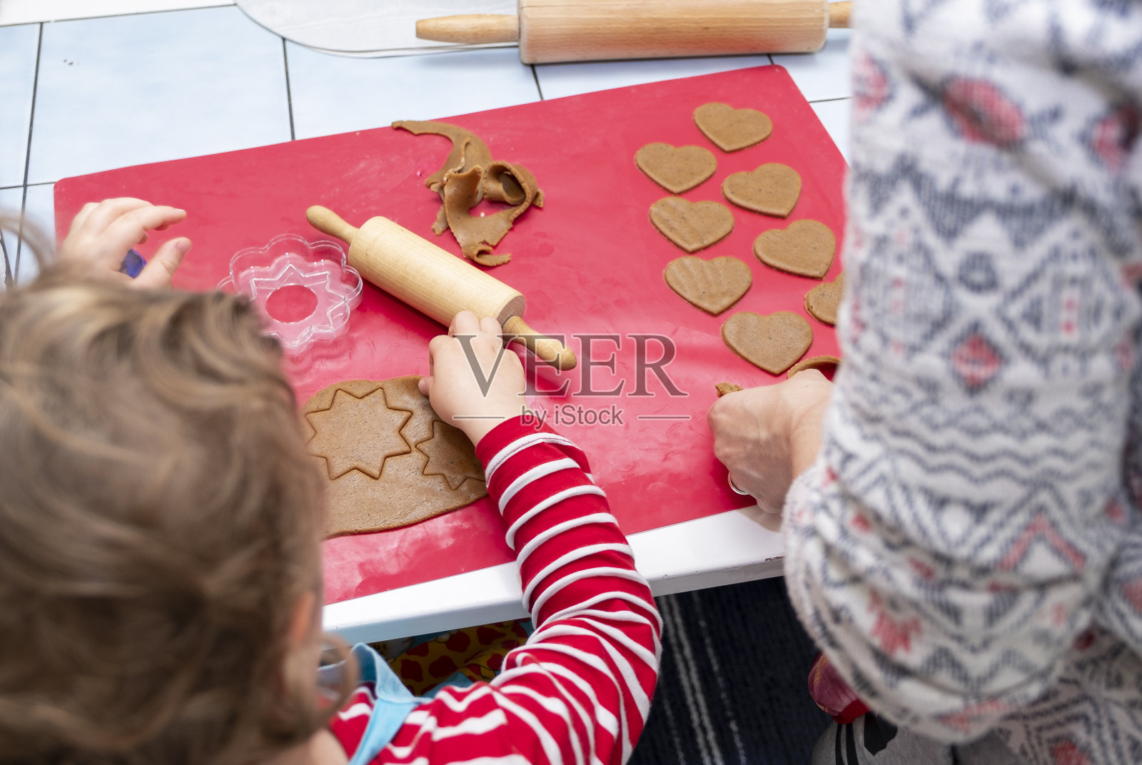 一个女孩和一个女人,白人,在厨房里烤姜饼。家庭问题。照片摄影图片