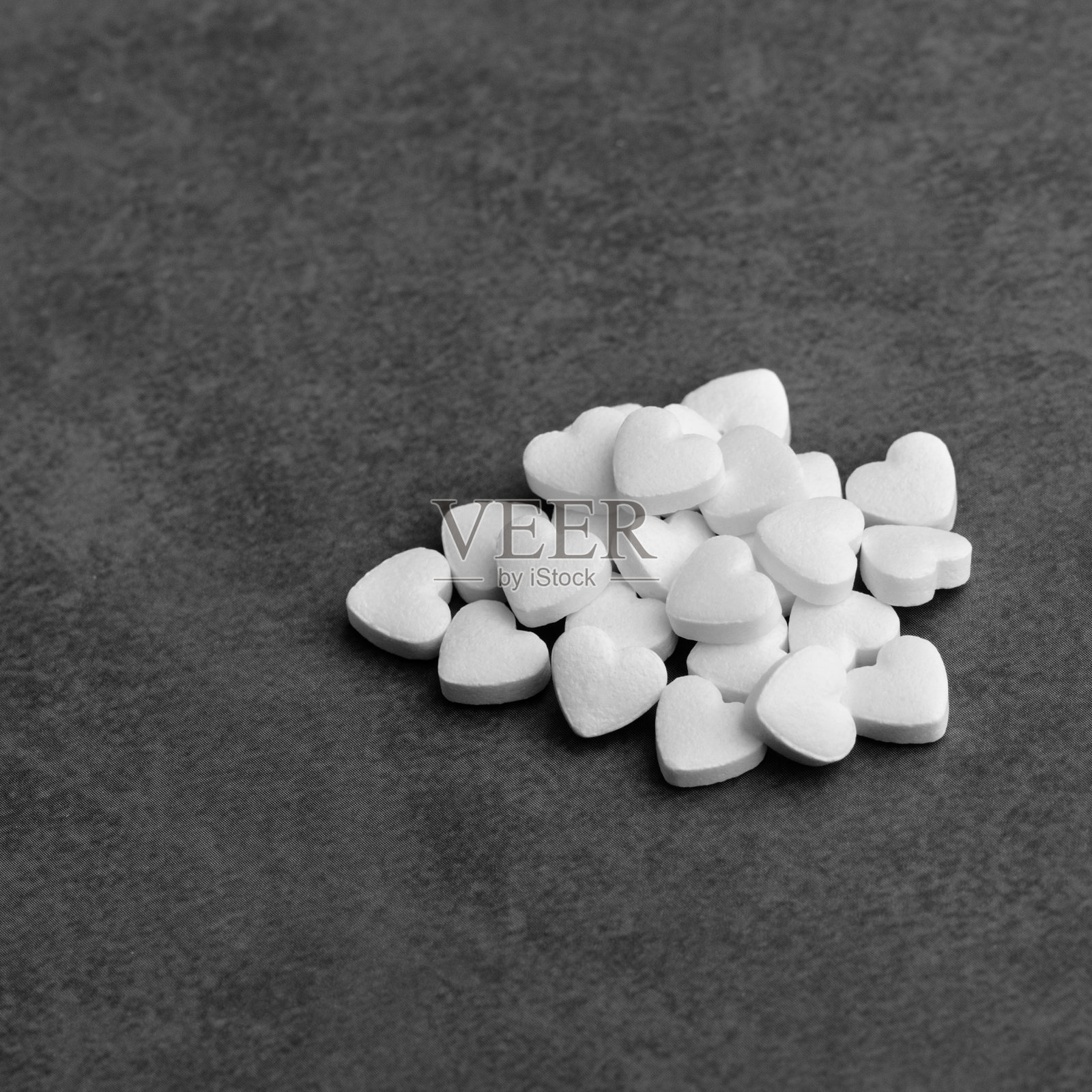 灰色背景上的心形白色药丸。照片摄影图片
