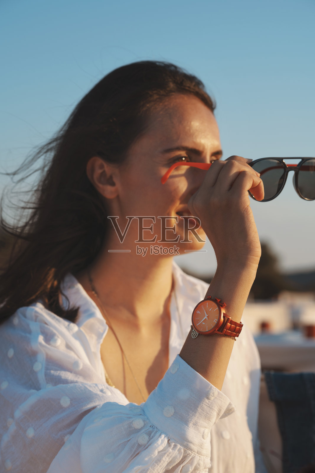 年轻女子戴着太阳镜看日落照片摄影图片