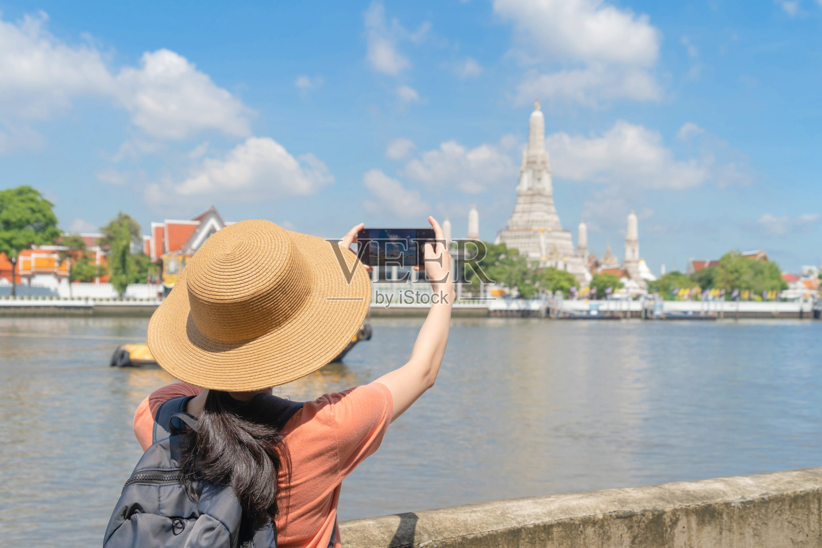 亚洲女人,一个旅游的人,旅行,用智能手机拍照在寺庙的黎明或Wat Arun和湄南河,曼谷,泰国。城市老城度假城。生活方式照片摄影图片