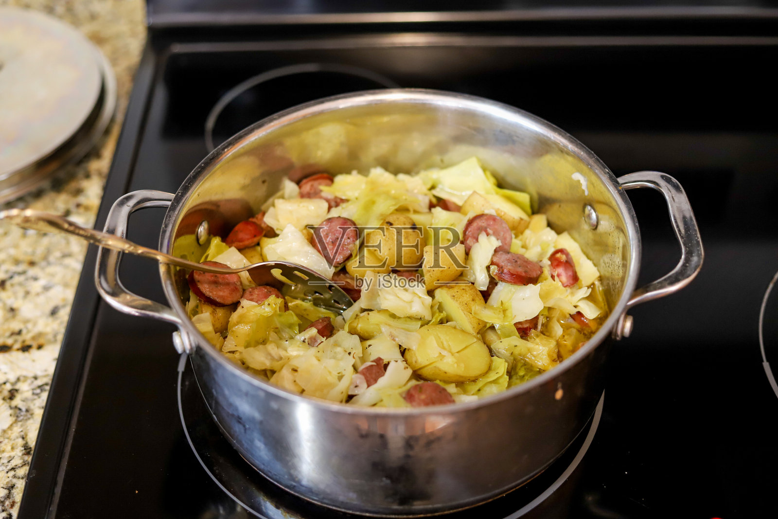 炉子上放着一锅卷心菜、土豆和波兰香肠照片摄影图片