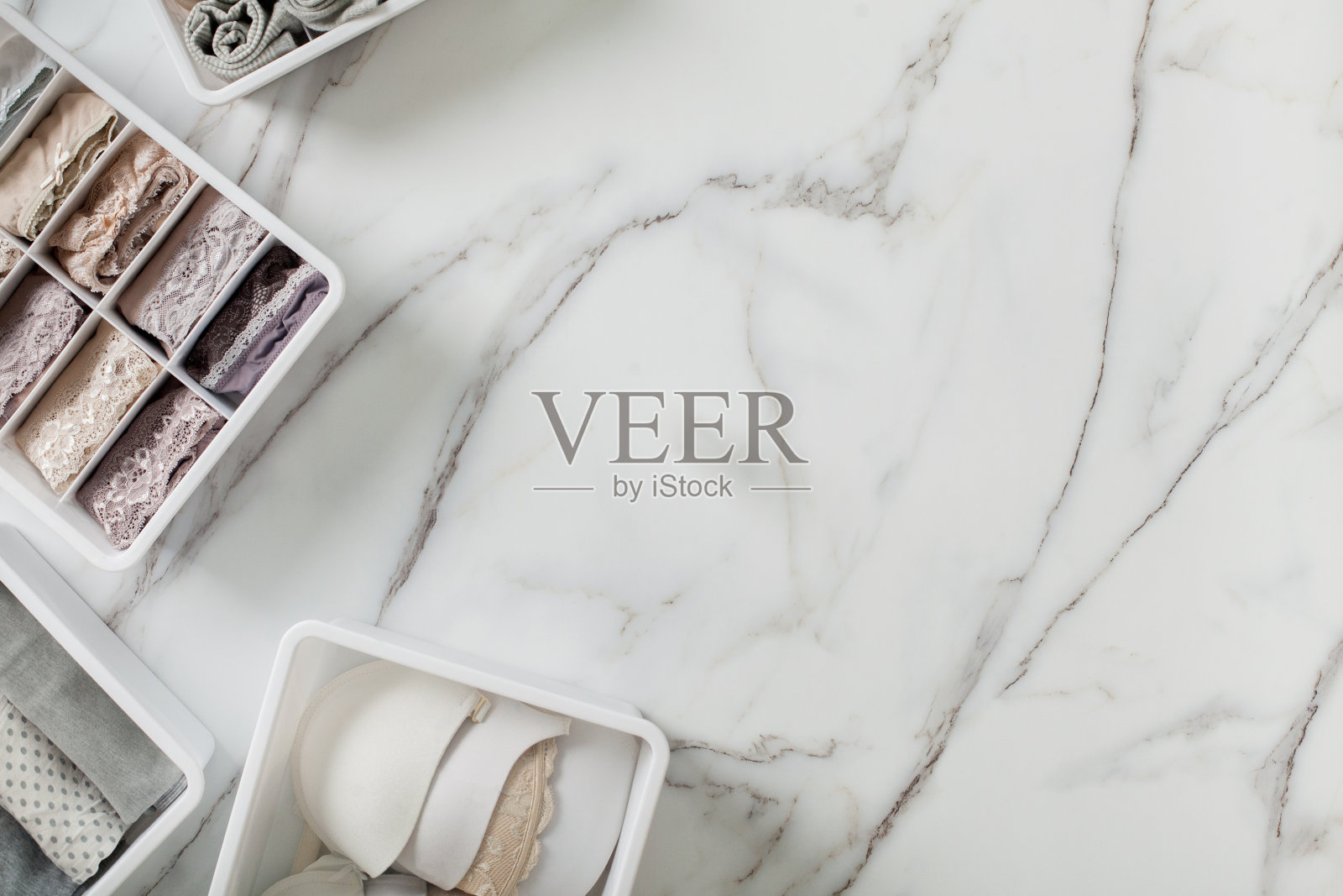 折叠整齐的内衣放在白色大理石背景的抽屉隔板里照片摄影图片