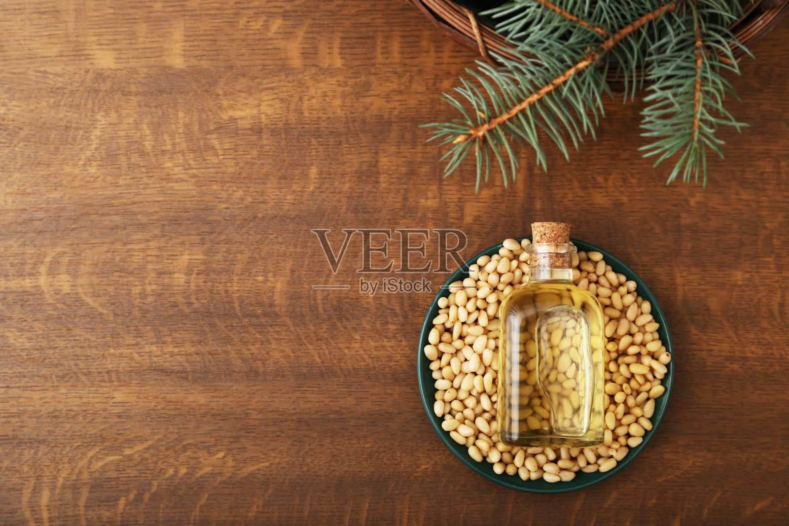 玻璃瓶里的雪松油,松子,木色背景上的早午餐。顶部视图与复制空间。照片摄影图片