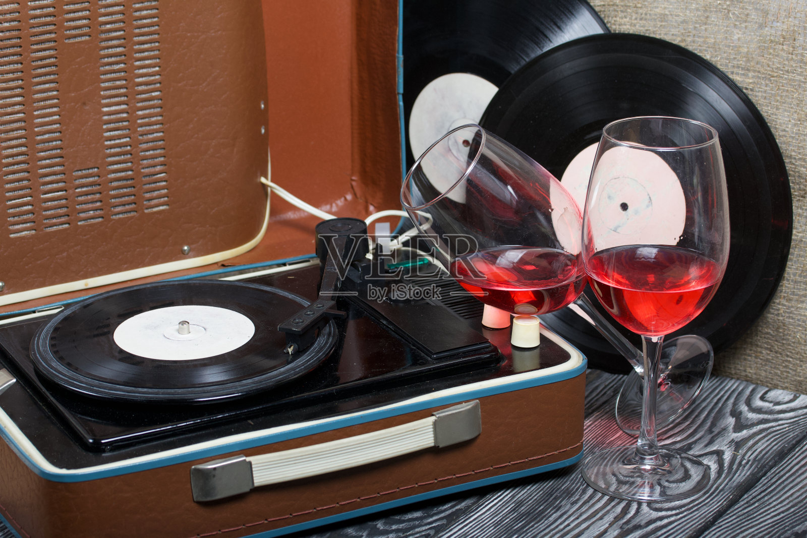 旧的转盘。旁边有两杯酒。复古方设备。照片摄影图片