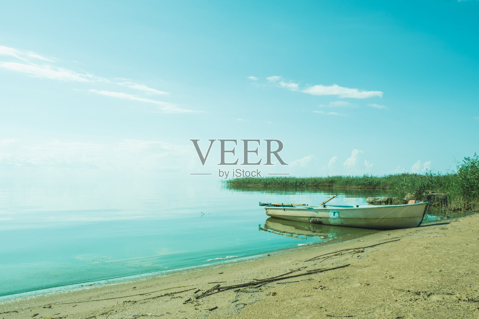 湖面上有一条白色的木船。照片摄影图片