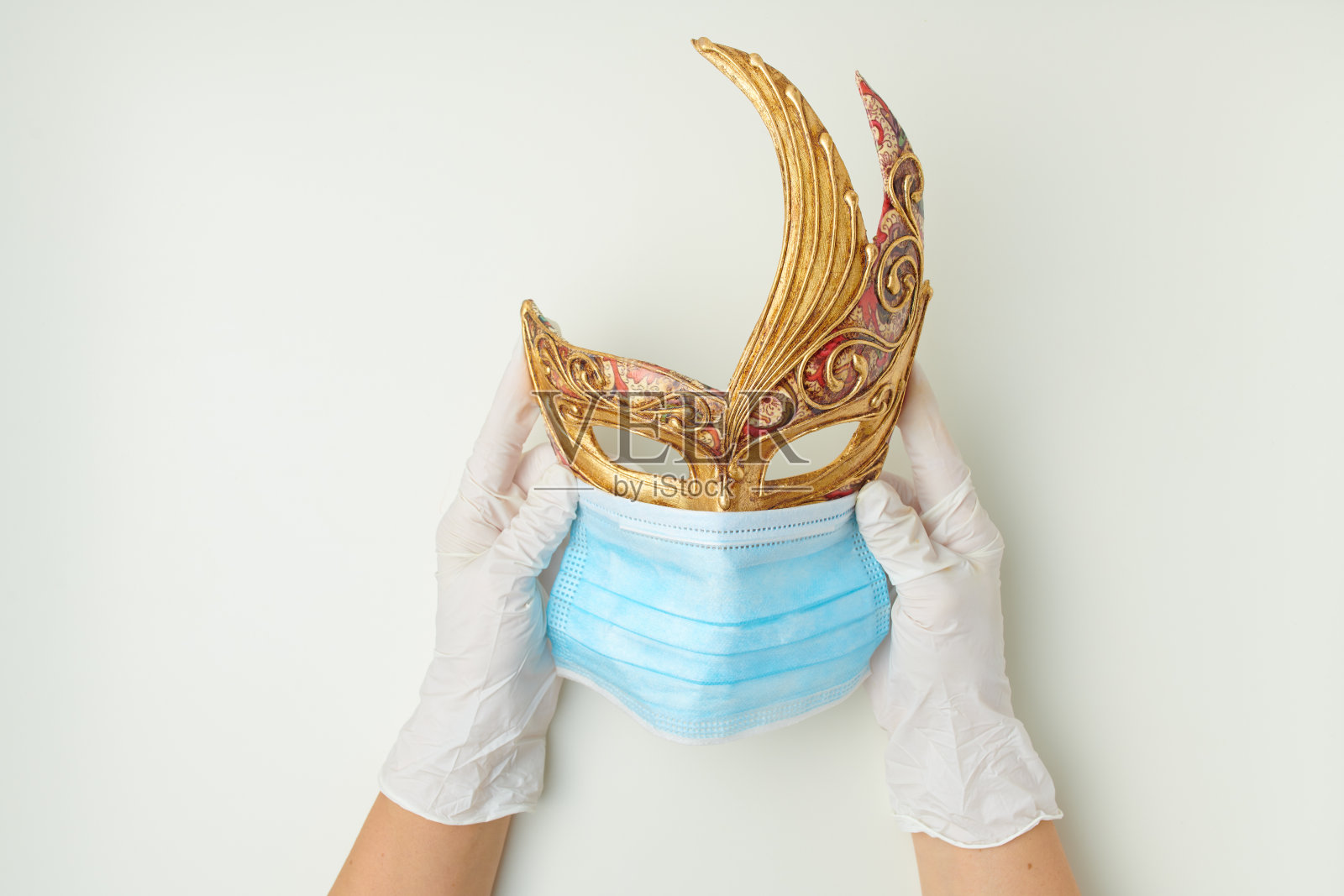 手戴橡胶手套,手持医用威尼斯口罩照片摄影图片