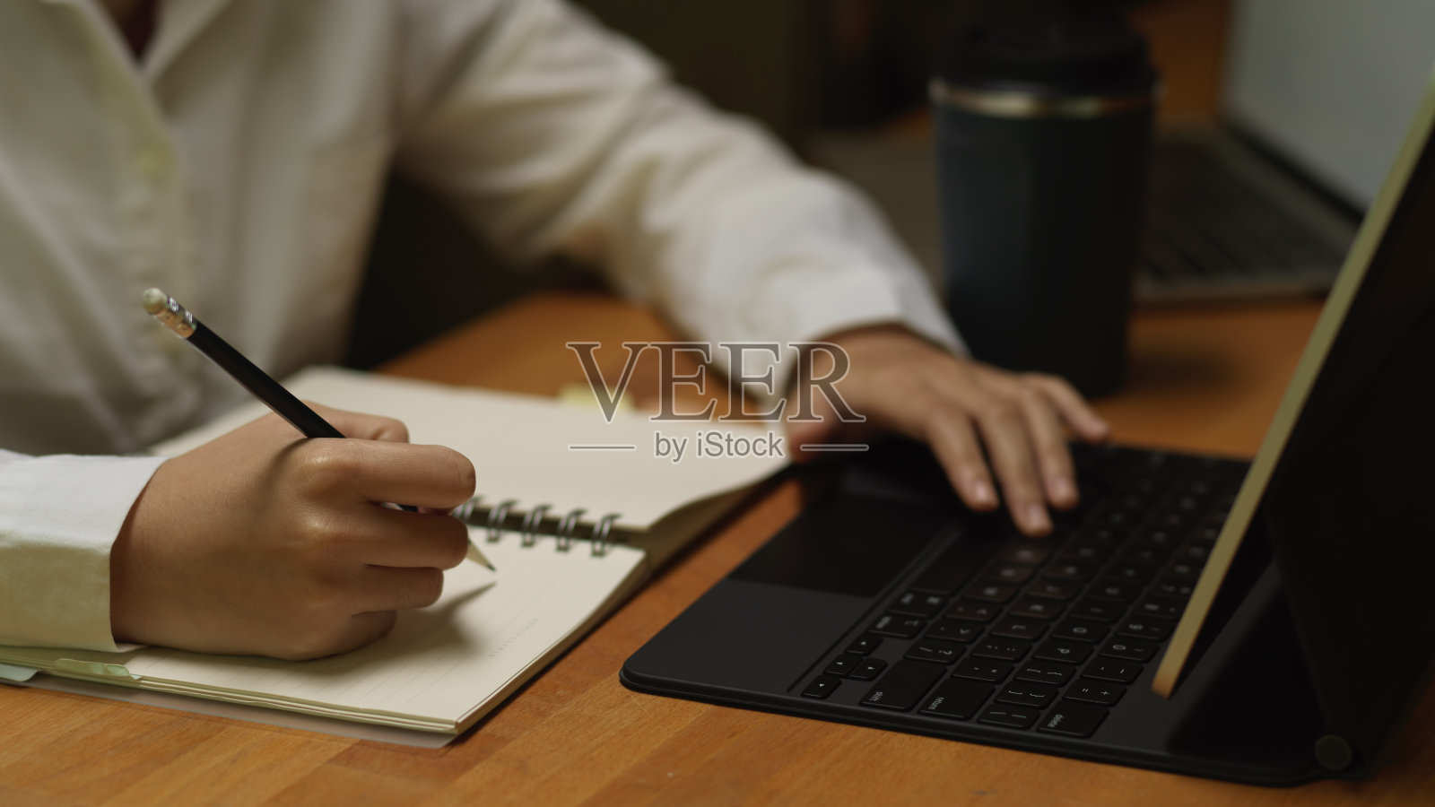 女性在木桌上工作时用笔记本做笔记照片摄影图片