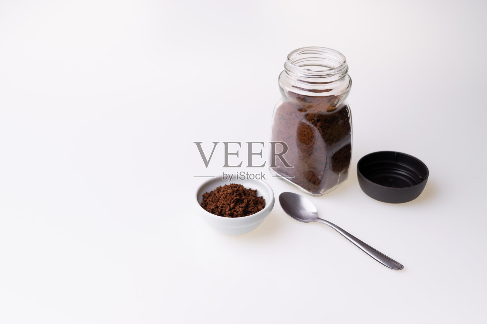 白色背景下的咖啡杯里的速溶咖啡颗粒照片摄影图片