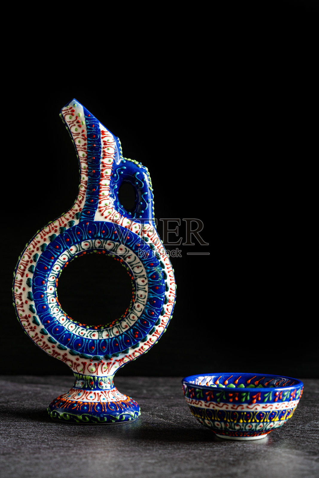 手工制作的赫梯陶瓷酒器瓶/手工工艺品,深色表面和背景上的传统图案。照片摄影图片