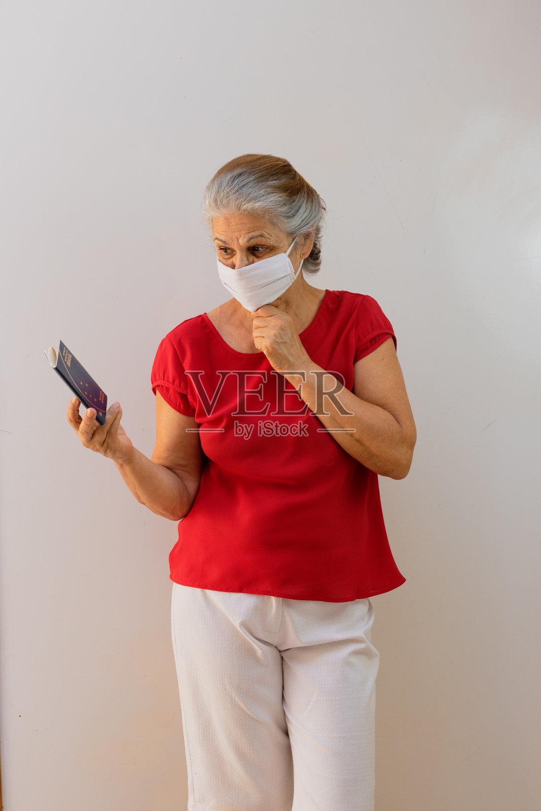 妇女成熟,戴着流感口罩,持有巴西护照照片摄影图片