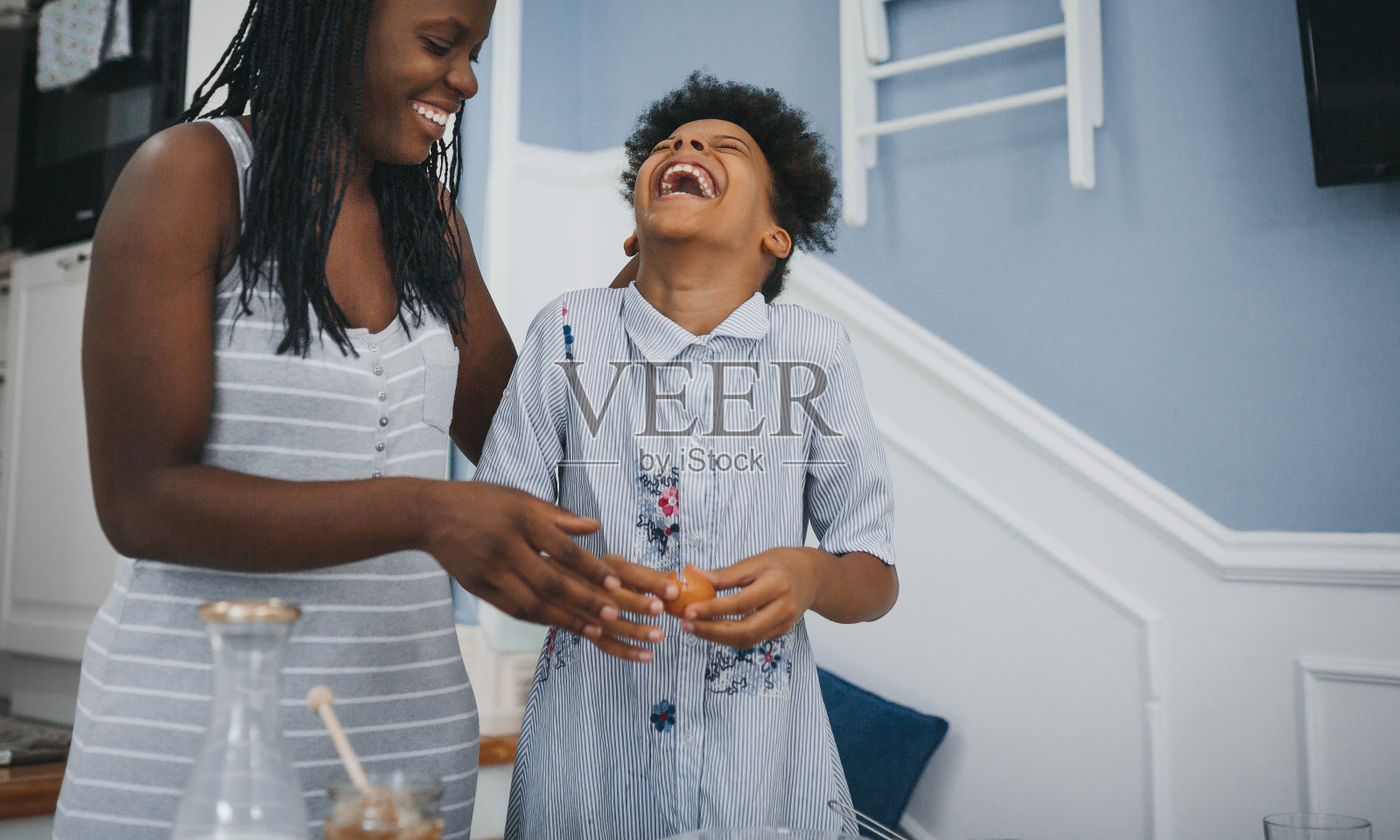 关心年轻的非洲裔美国母亲帮助小女儿做面包照片摄影图片