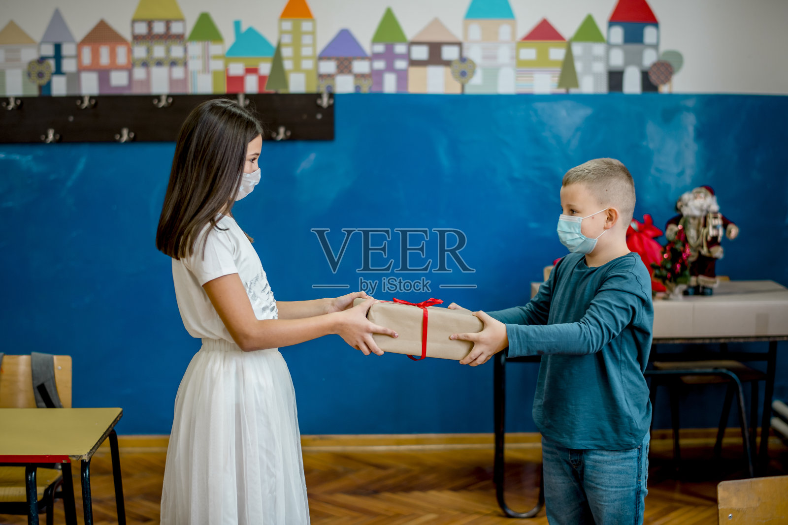 学校的孩子们在教室里庆祝新年。他们戴着防护口罩。照片摄影图片