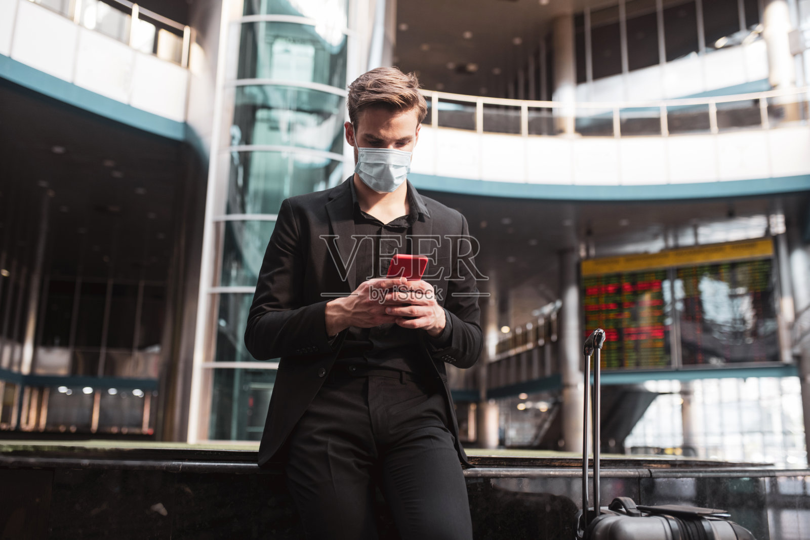 一名男子在机场用智能手机照片摄影图片