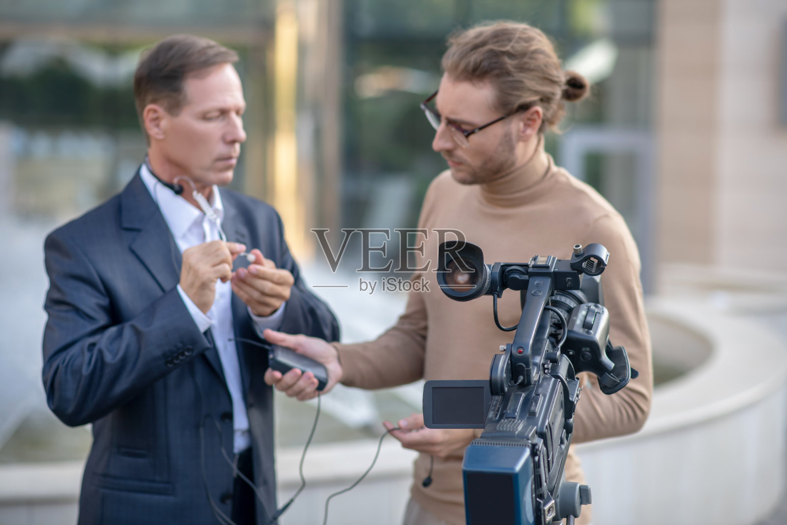 金发接线员帮男记者戴上耳机照片摄影图片