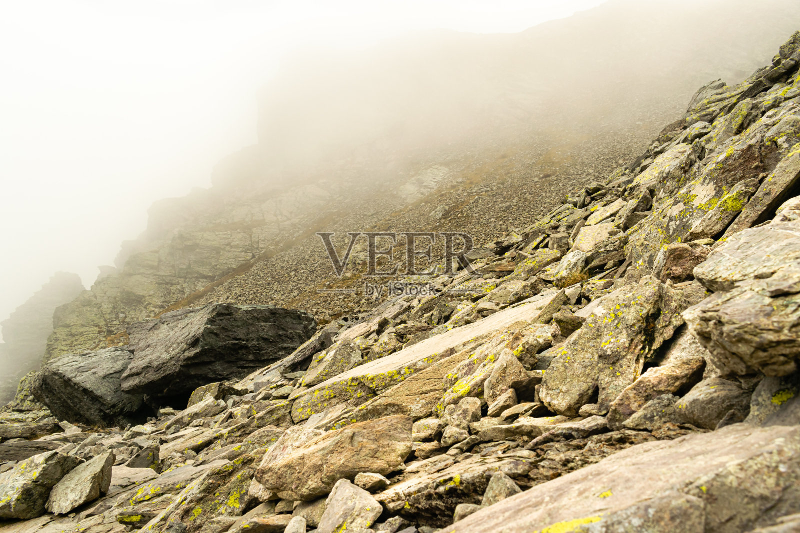风景蒙特阿瓦罗,库西奥,贝加莫,意大利。在一个多雾的秋日,岩石斜坡照片摄影图片