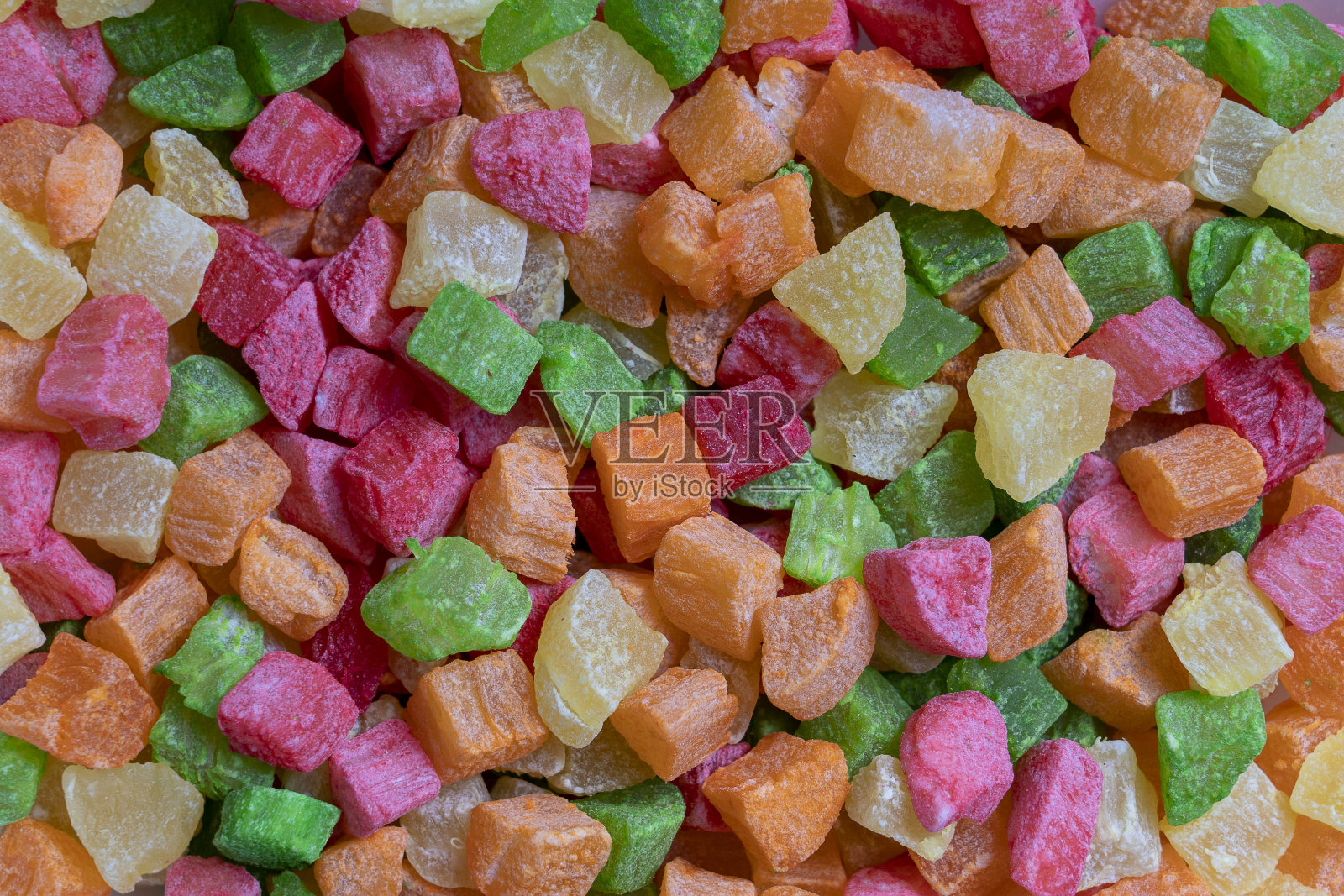 背景蜜饯五颜六色的水果。菠萝干碎片。有颜色的热带干果。近距离照片摄影图片