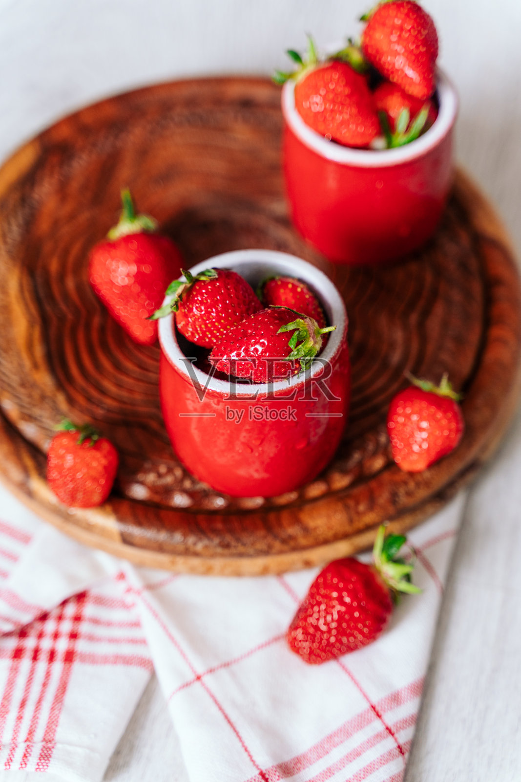 新鲜的草莓在红色的锅上,在一个木制的背景,水滴浆果。健康营养,维生素充电,夏季浆果照片摄影图片