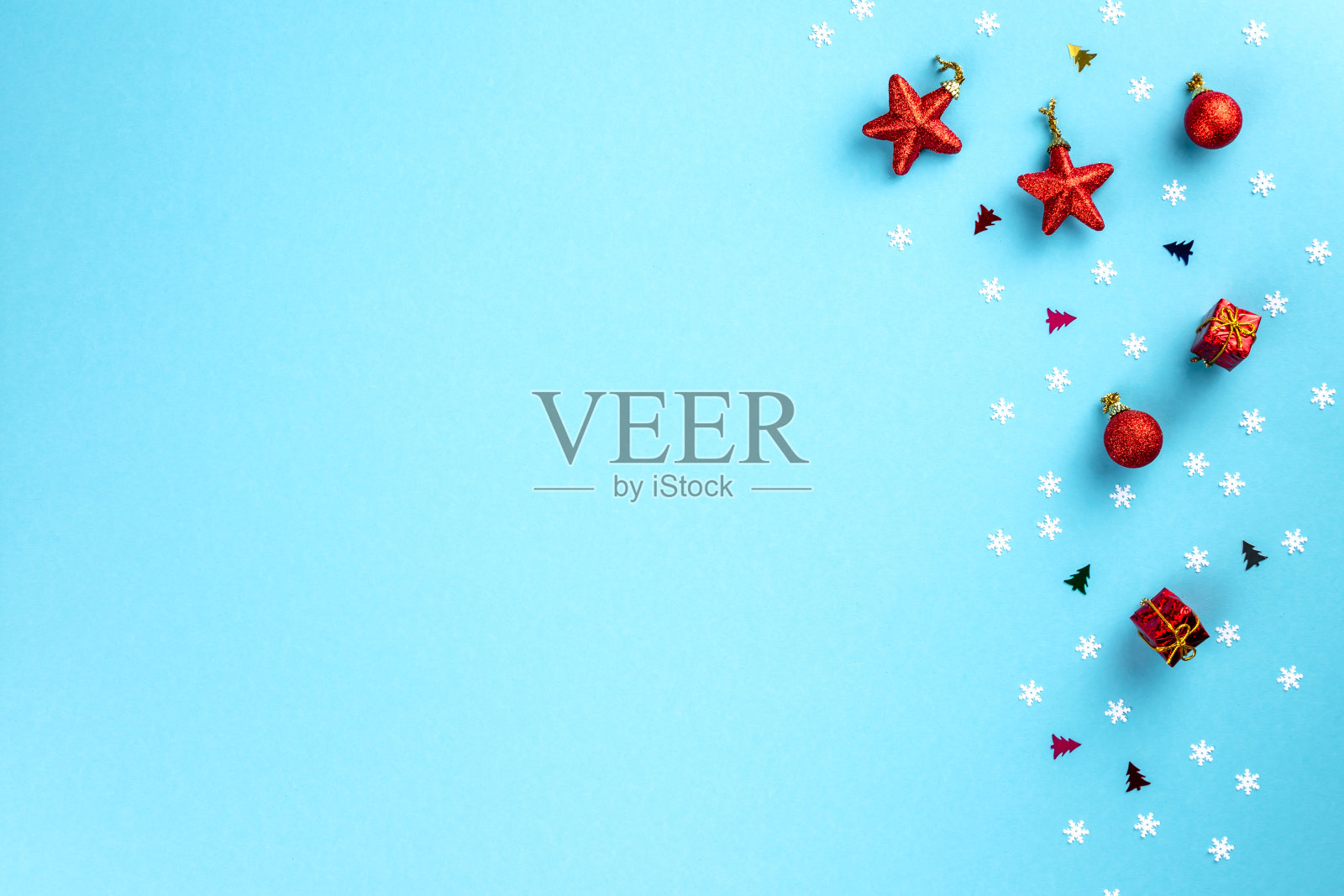 圣诞和冬季作文。粉彩蓝色背景上的白色雪花和红色玩具制成的框架。圣诞节,冬天,新年的概念。平铺,俯视图,拷贝空间照片摄影图片