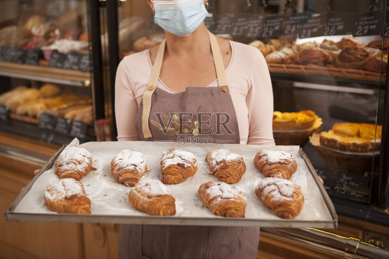 成熟的女性面包师在她的店里工作照片摄影图片