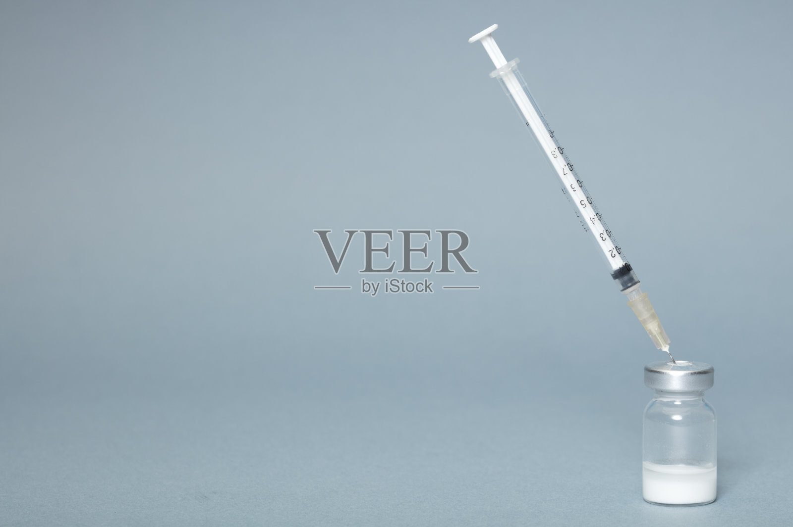 灰色背景上的注射器和安瓿,接种疫苗。照片摄影图片