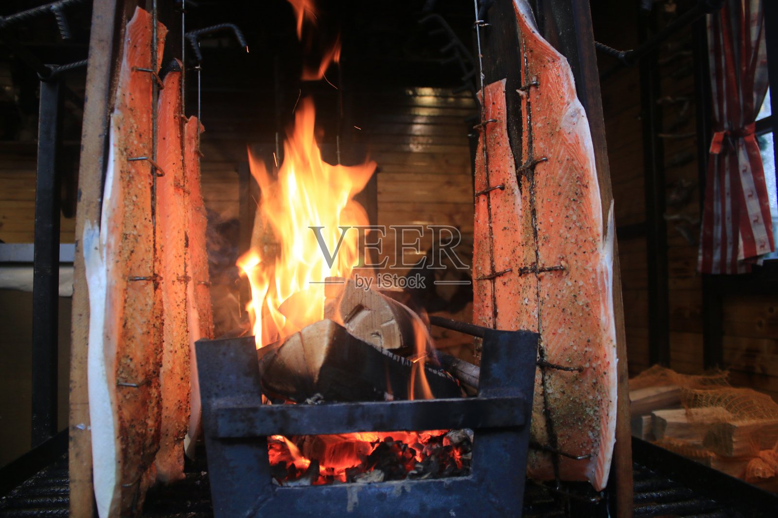 三文鱼片在火上用传统的方法熏制/烹饪,用木盘来保持三文鱼的口感照片摄影图片