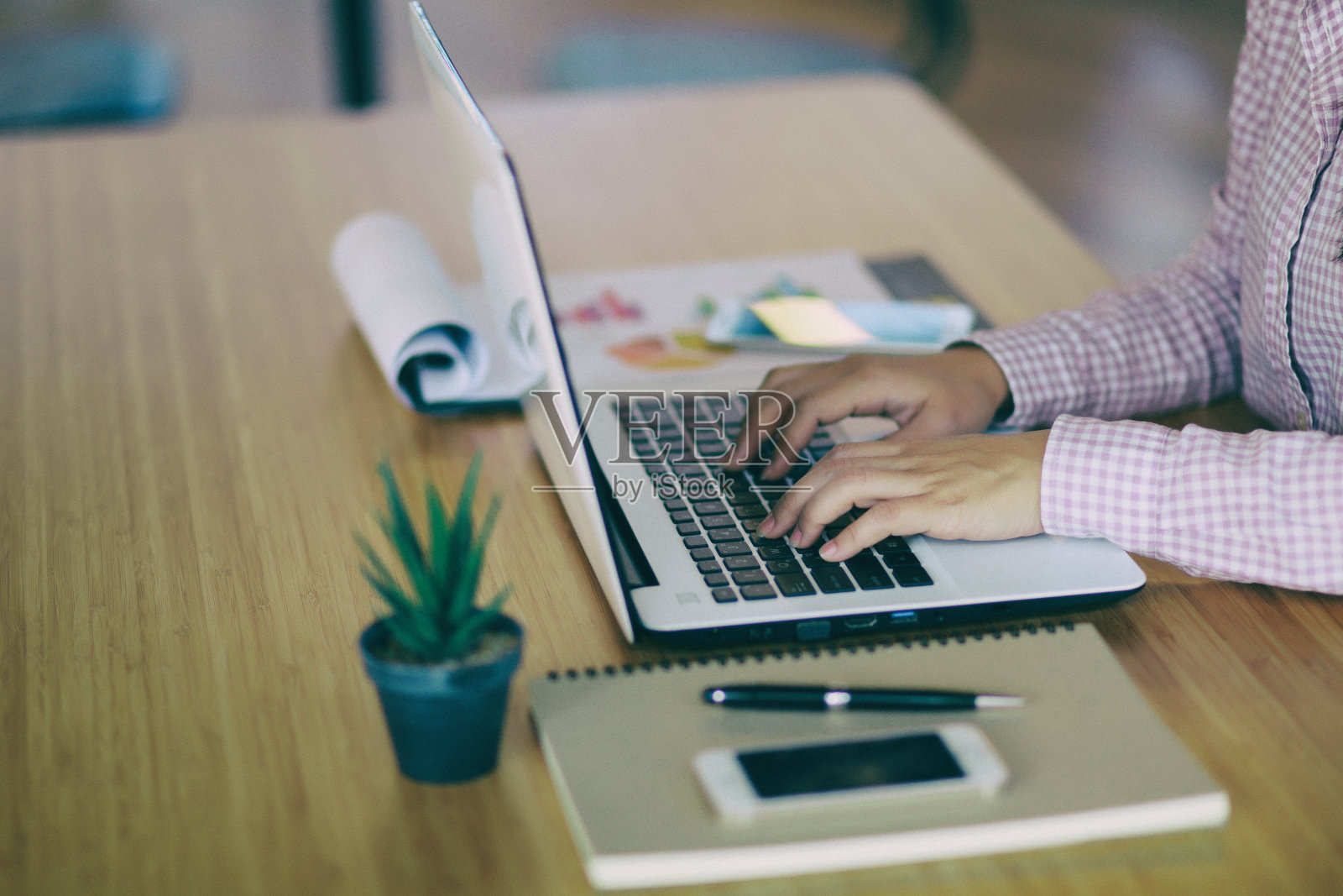 自由职业女性坐在咖啡店里用笔记本电脑进行远程工作。职场女性在笔记本电脑上打字在家办公的女性使用手写键盘。照片摄影图片