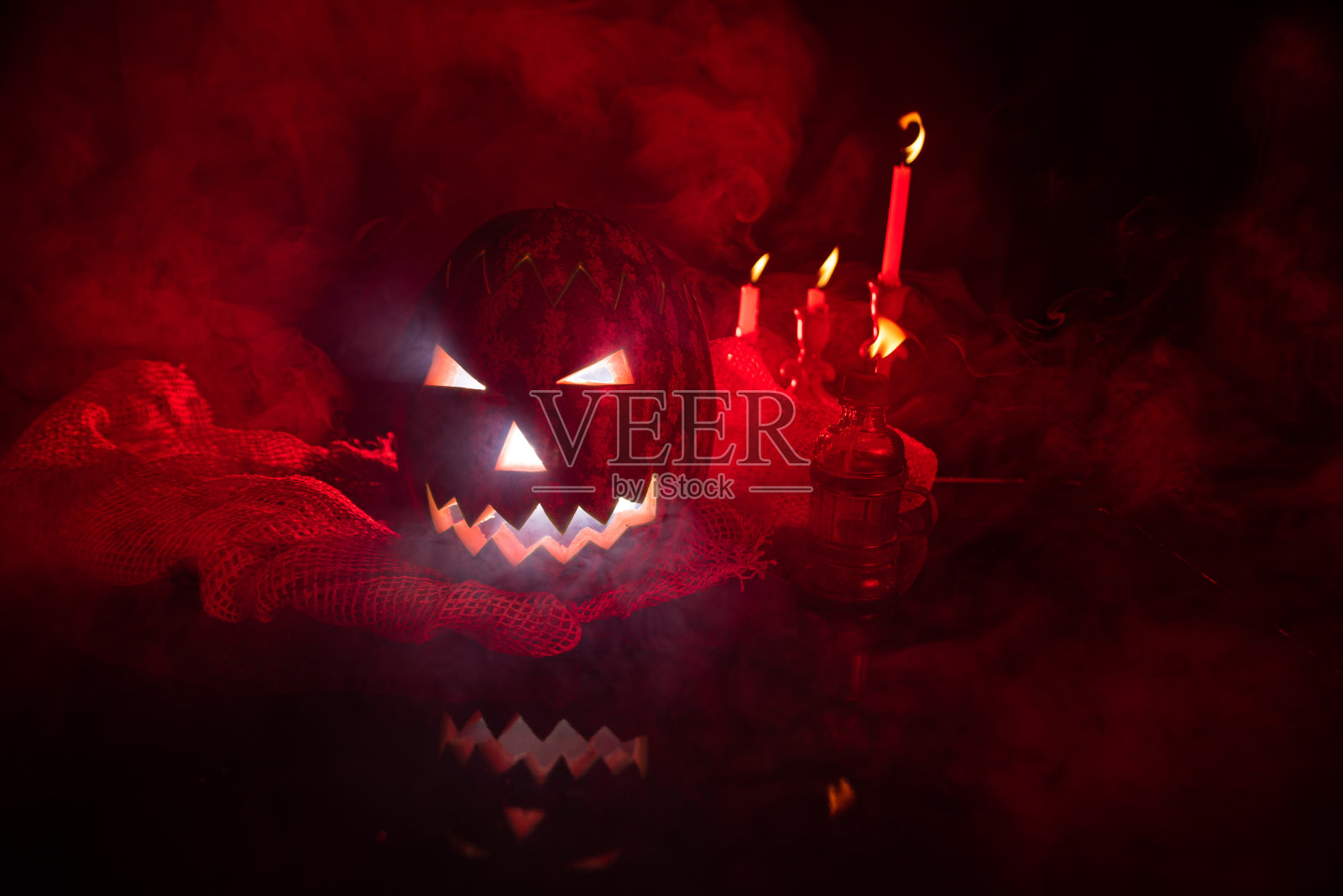 来自巴西的杰克南瓜头用西瓜制作,低调的肖像,恐怖的肖像,红色闪光和很多烟雾的场景。有选择性的重点。照片摄影图片