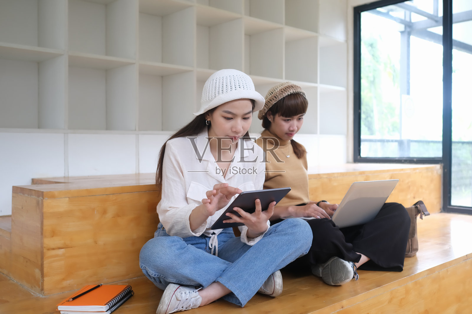 两个年轻的女设计师在办公室一起计划他们的项目。照片摄影图片