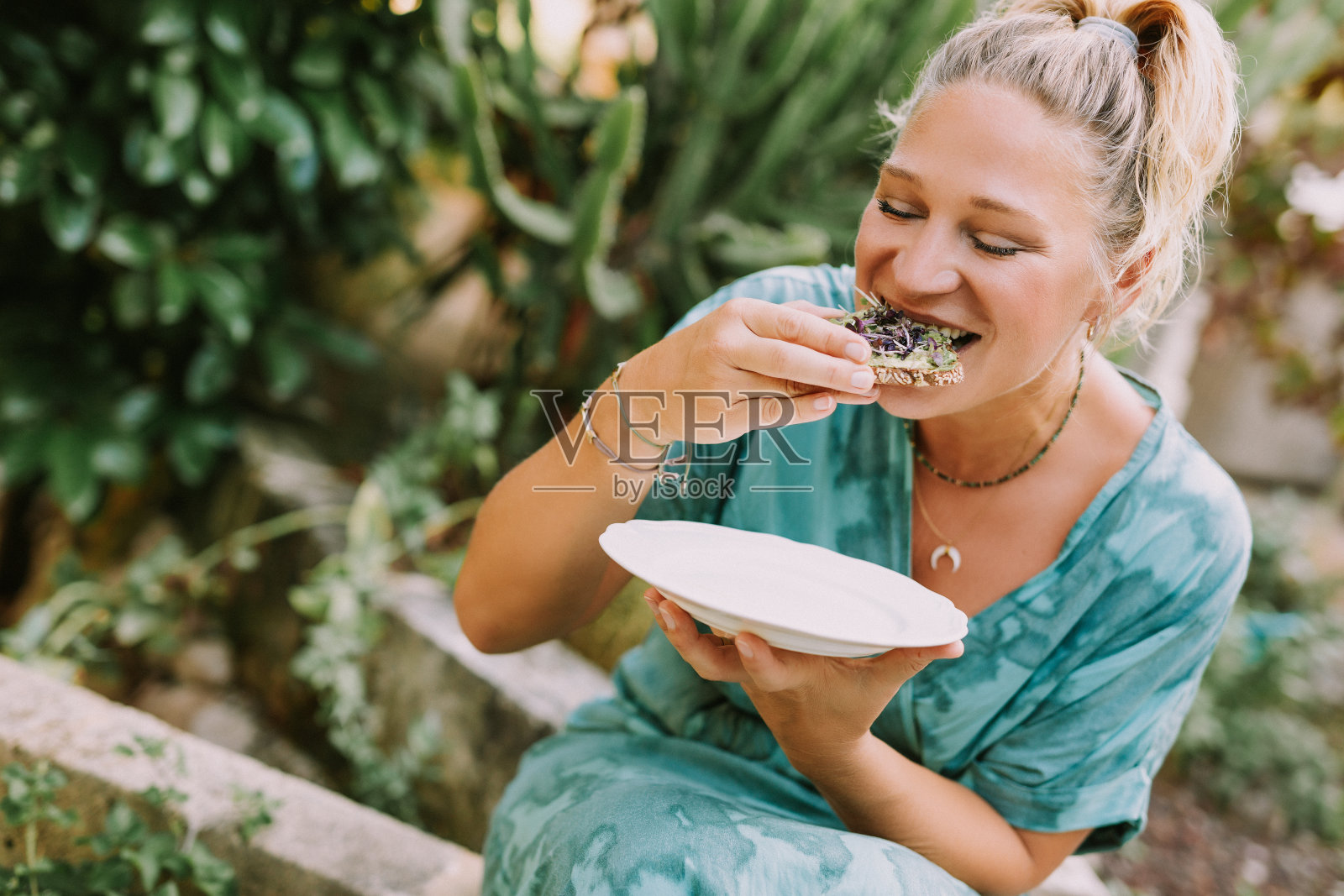 年轻女子品尝自制鳄梨面包照片摄影图片