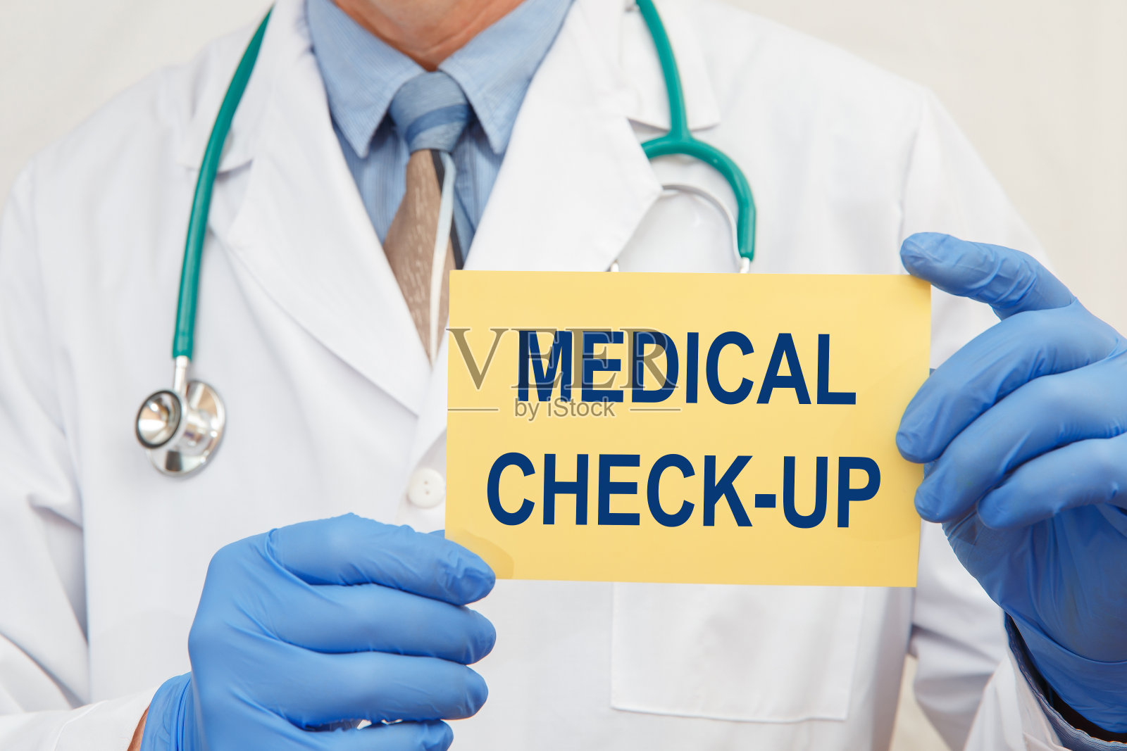 一个男性医生举着一个标志与文本体检的特写照片摄影图片