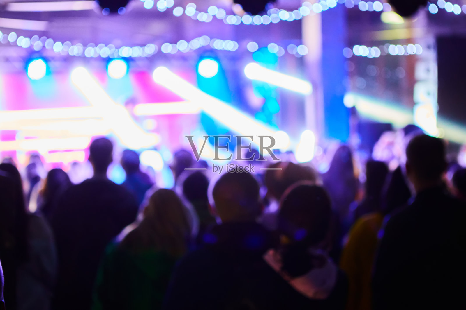 音乐会背景模糊。模糊的人跳舞与原始的散焦灯光在背景-散焦图像的艺术触摸迪斯科俱乐部-与音乐和娱乐夜生活的概念照片摄影图片