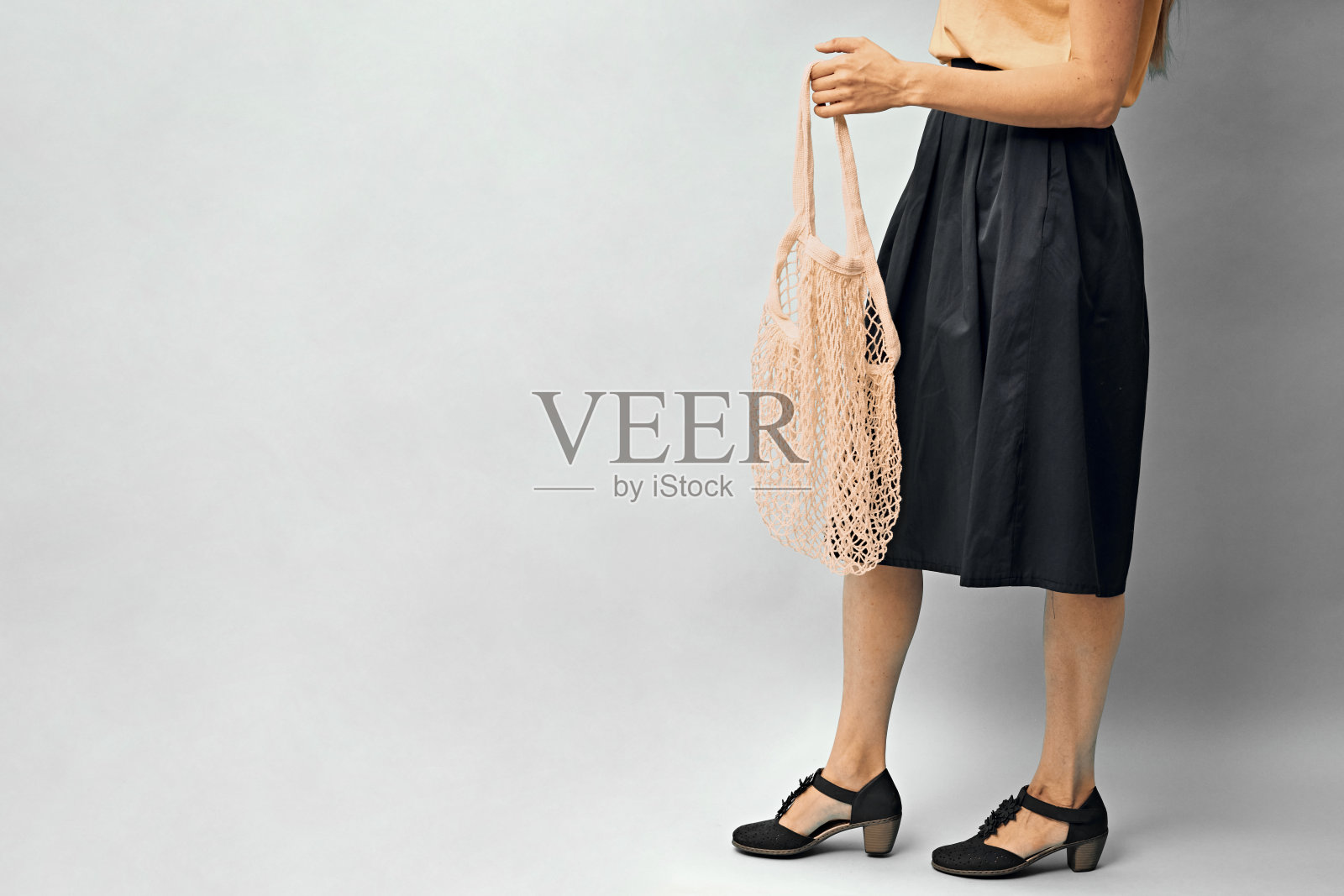 女孩手里拿着一个空的网袋。一个女孩手里拿着一个环保袋。环保包装。本空间照片摄影图片