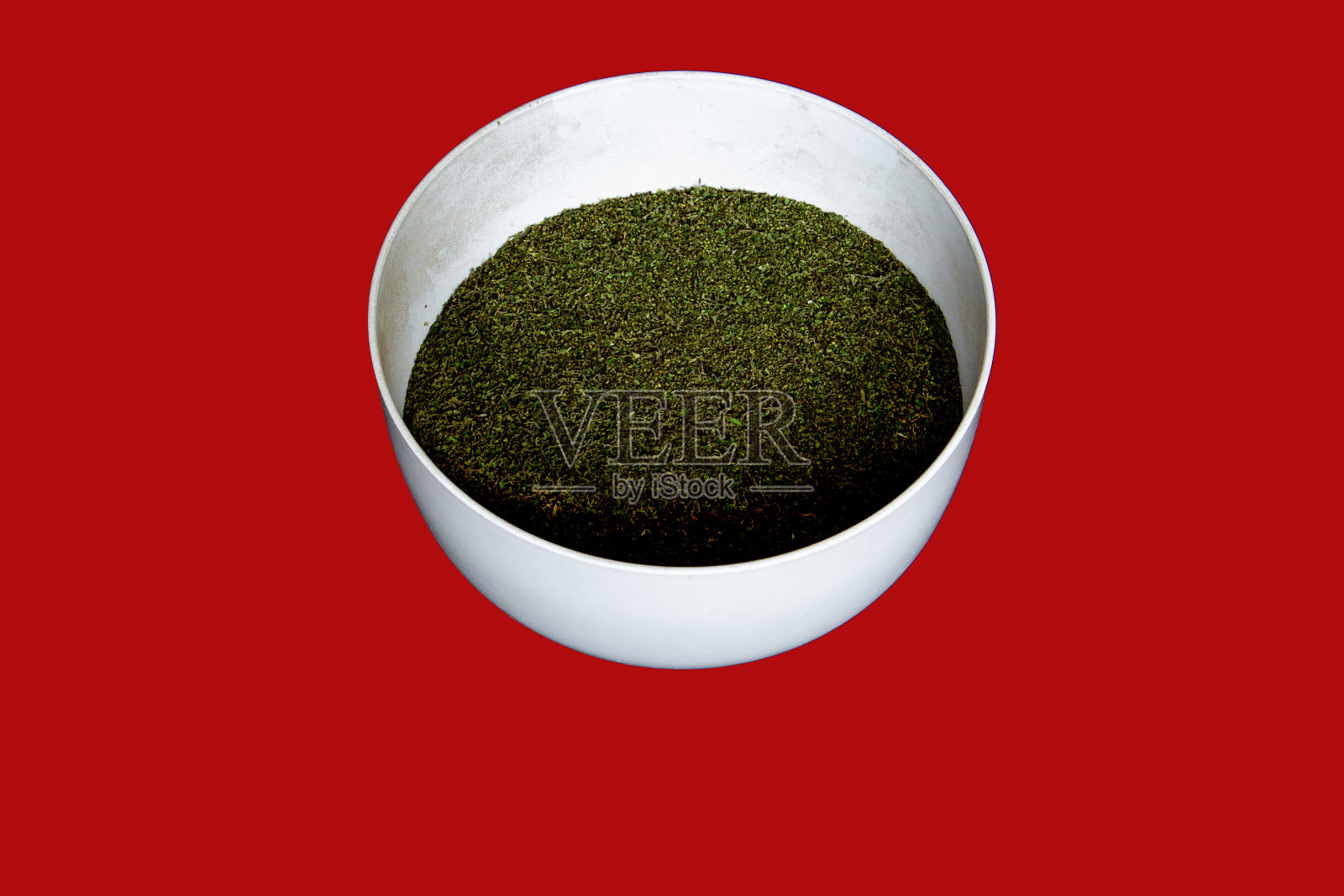 红色背景上的荨麻干籽白碗照片摄影图片
