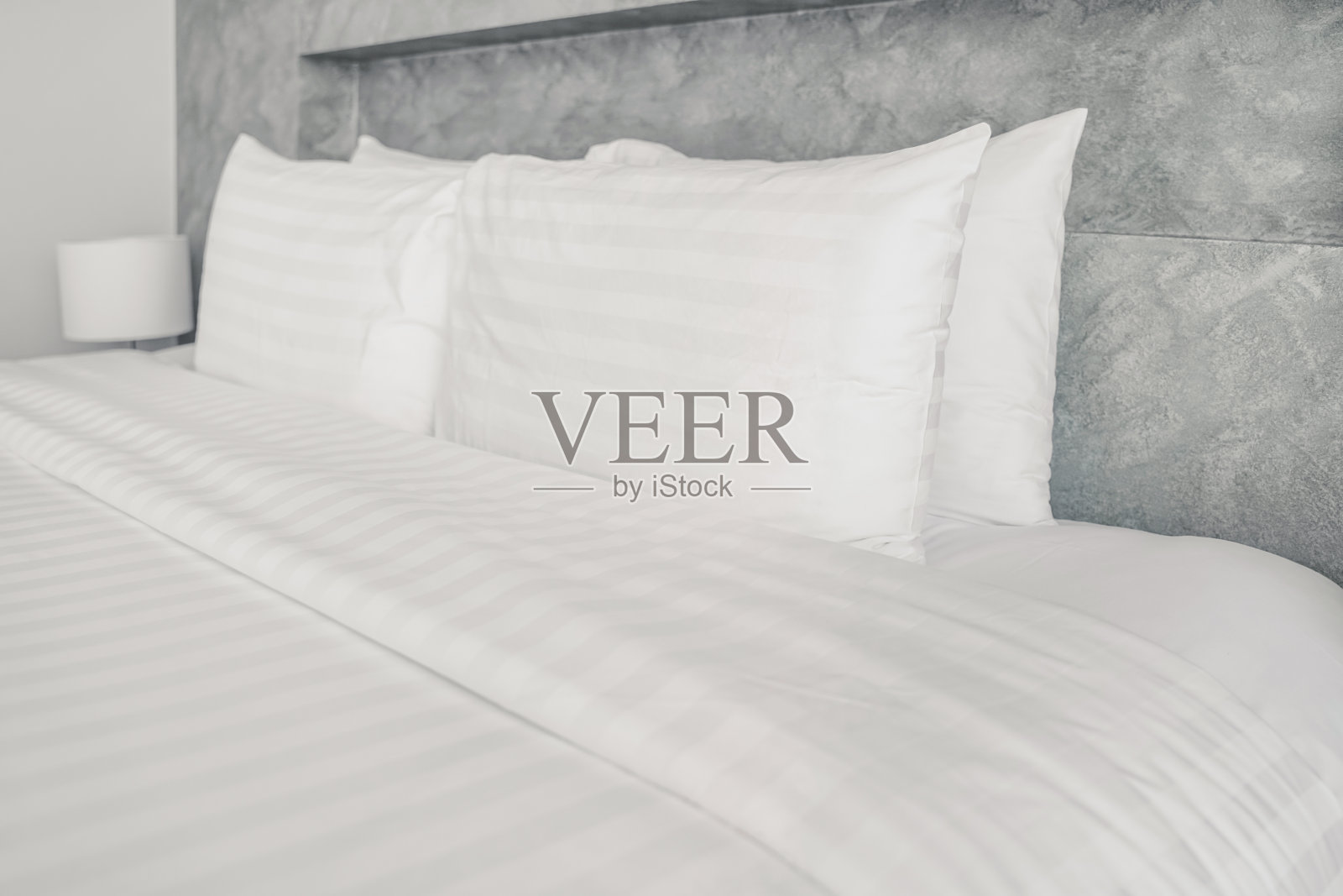 近距离的白色枕头在豪华酒店的房间清洁床上,在柔软的焦点照片摄影图片