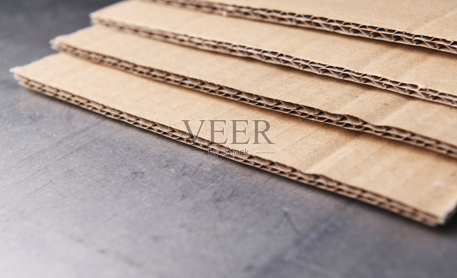 棕色瓦楞纸板在灰色钢背景上。照片摄影图片