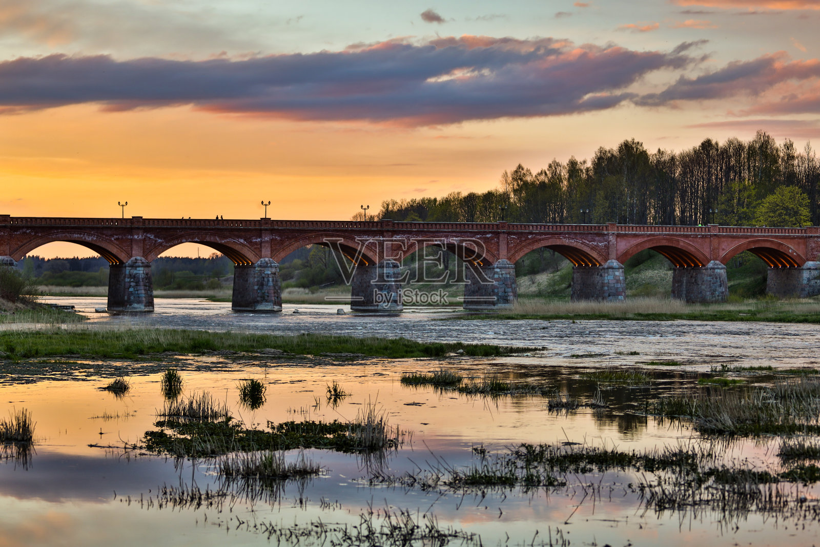 Venta河上古老的砖桥傍晚日落的景色。照片摄影图片