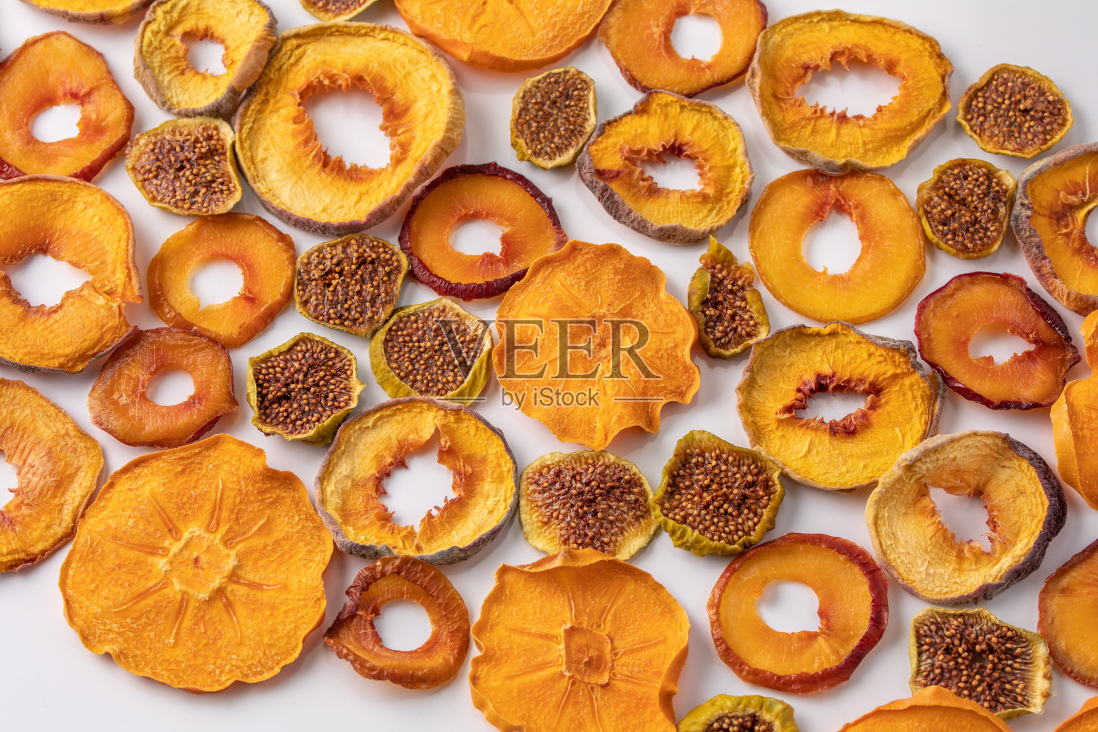 白底上的柿子、桃、李子干和无花果片。干果。生态。照片摄影图片