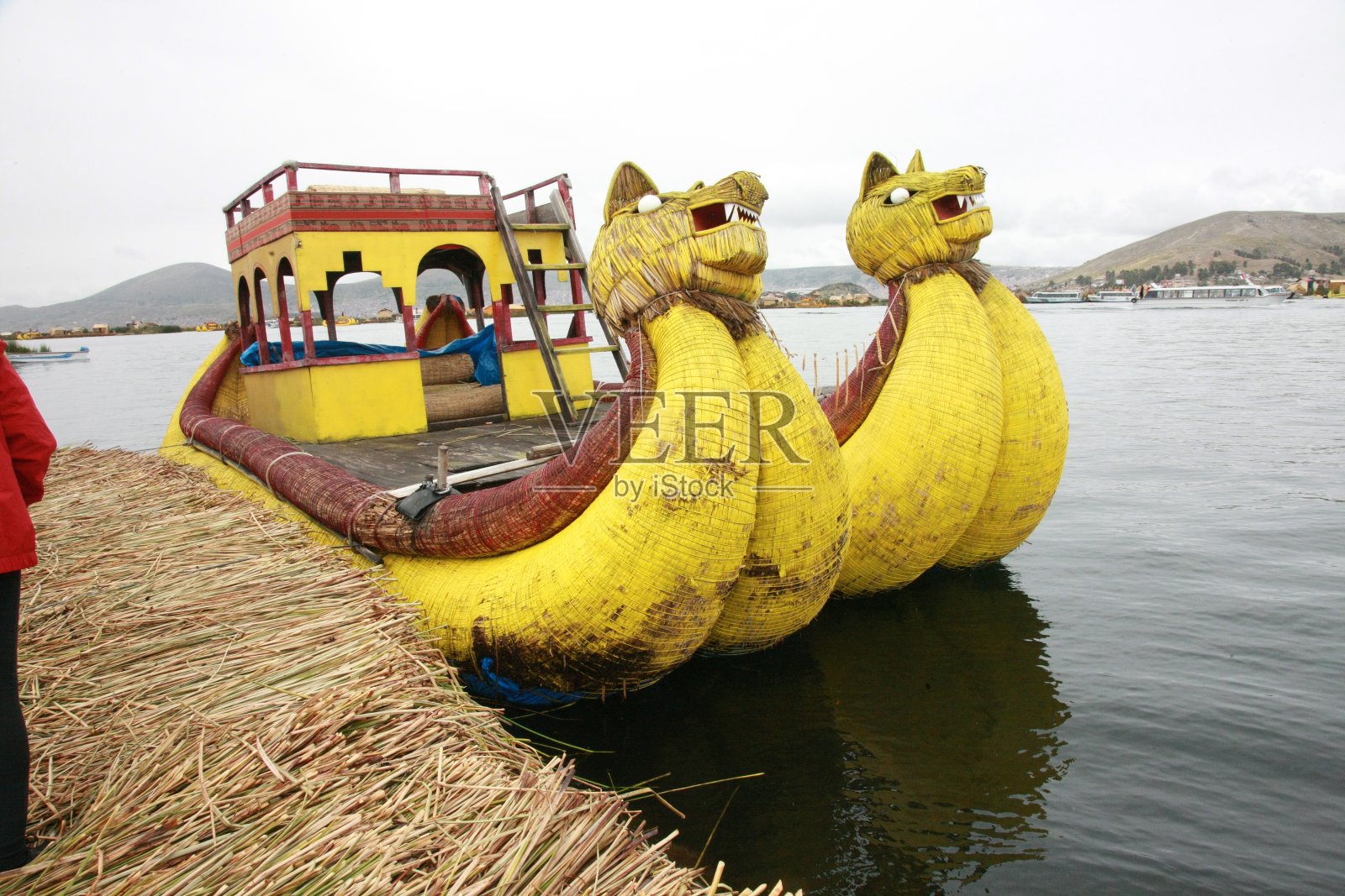 南美洲秘鲁的喀喀湖,两艘由当地印第安人用芦苇制成的著名的黄色龙头船照片摄影图片