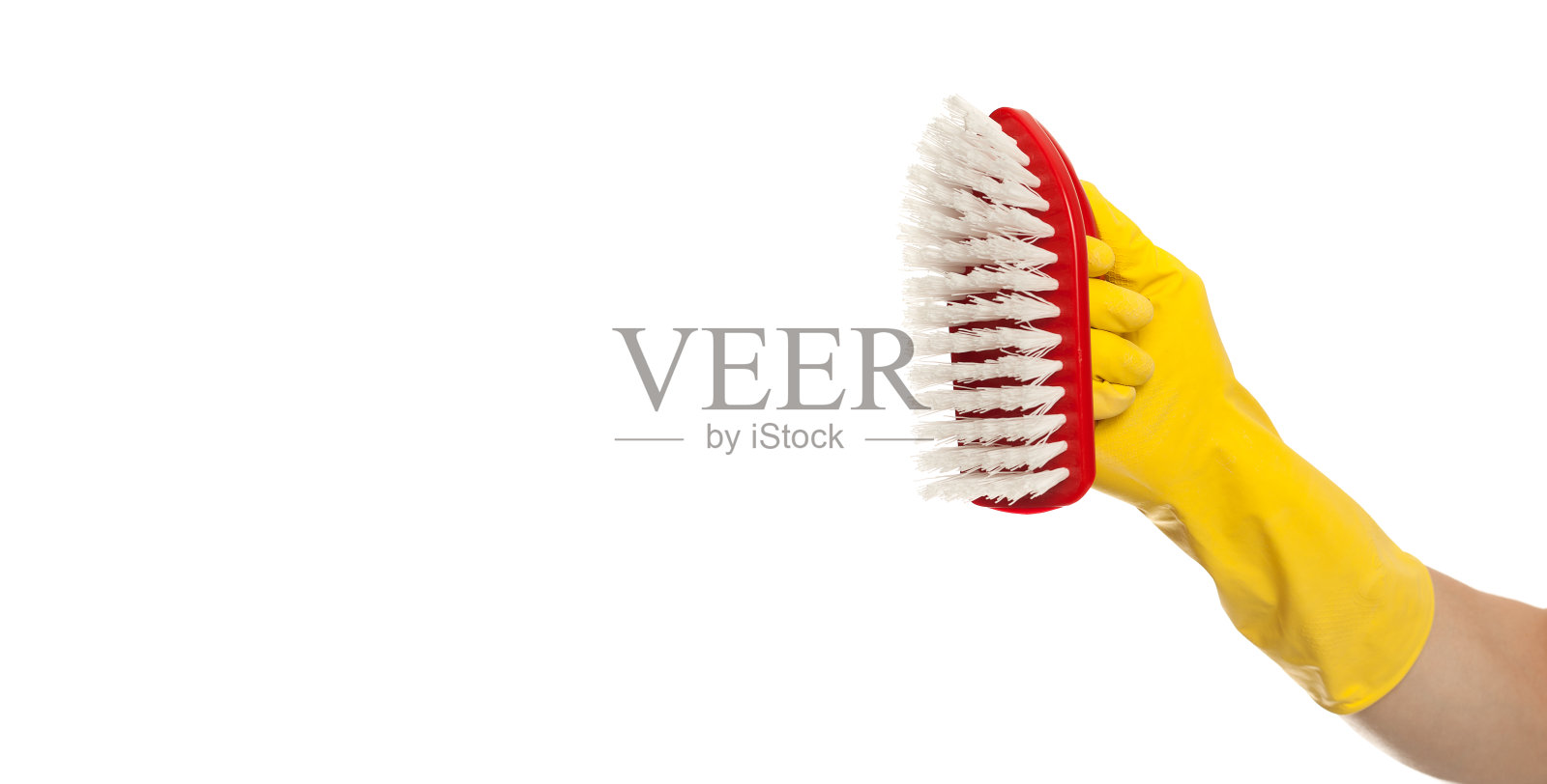 在白色的背景上,手拿黄色的手套和红色的清洁刷。家里清洁概念照片摄影图片