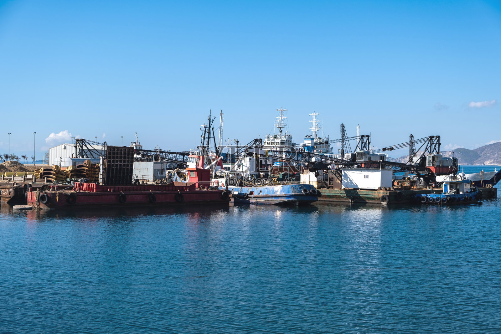 在阳光明媚的希腊比雷埃夫斯德拉佩索纳旧港,船只停泊。照片摄影图片