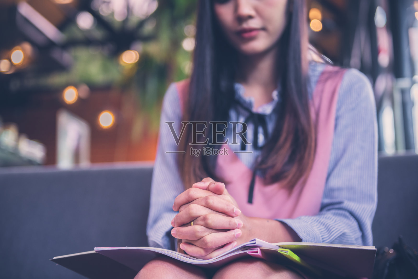 亚洲基督教妇女祈祷,手在书照片摄影图片