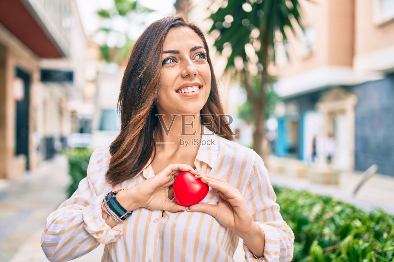 年轻的西班牙妇女微笑着在城市的心脏。照片摄影图片