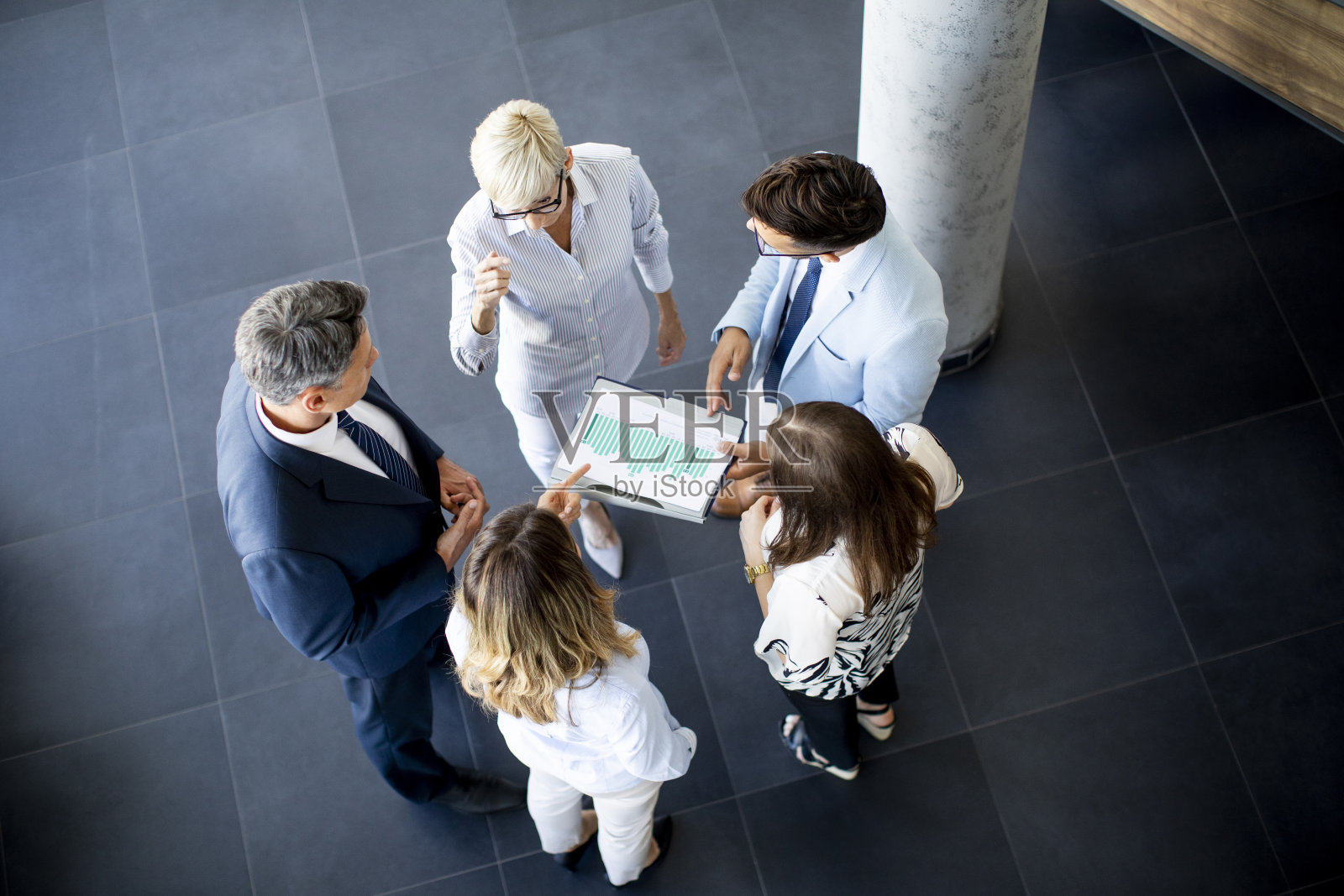 一群商务人士站在办公室里分析计划照片摄影图片