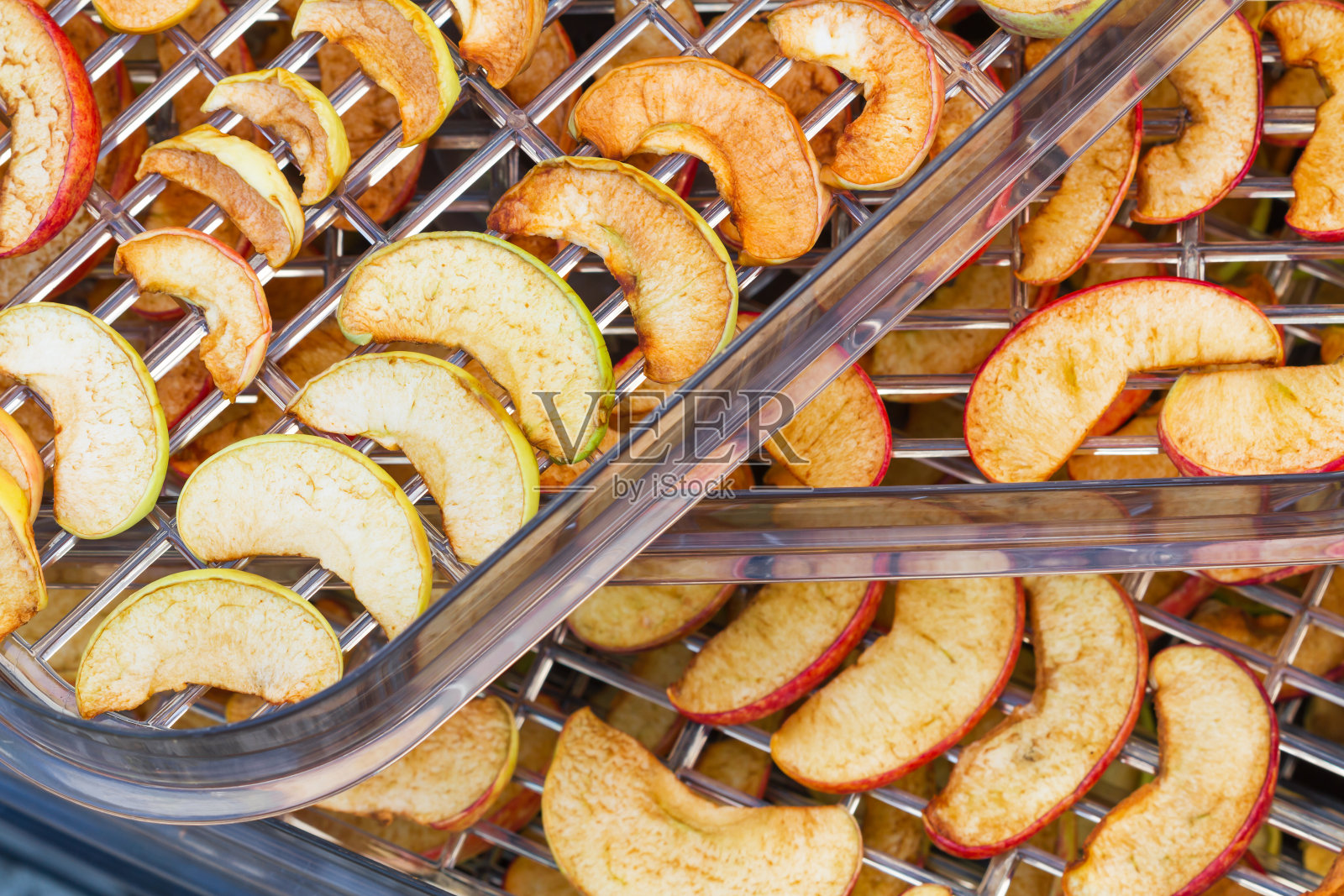 切片苹果放在食品烘干机里。把苹果切在脱水机托盘上。特写镜头,有选择性的重点照片摄影图片